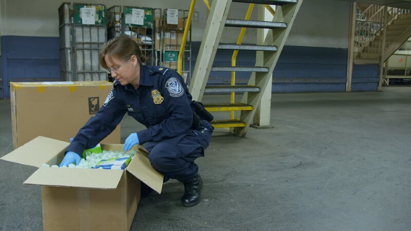 CBP Supervisor Grob inspects a package for contraband at the JFK mail facility. – Bild: National Geographic/​Lucky 8 TV