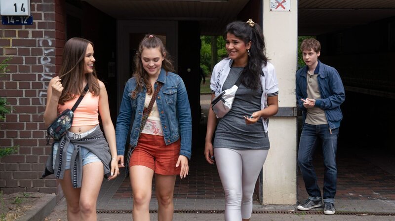 Lukas Berger (Filip Januchowski, r.) traut sich nicht, Pia Stern (Amelie Hennig, M.) anzusprechen (mit Komparsinnen). – Bild: ARD/​Georges Pauly /​ ARD-Programmdirektion
