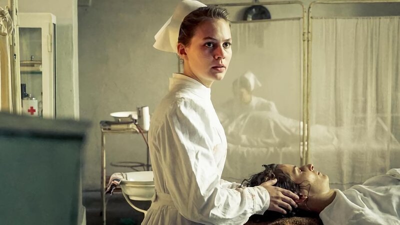 Ida (Alicia von Rittberg) assistiert bei der Operation von Hedda Ehrlich (Stella Hilb). – Bild: ARD/​Nik Konietzny