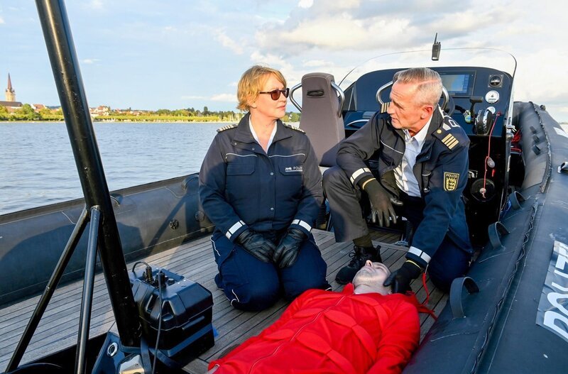 Nele Fehrenbach (Floriane Daniel, l.) und ihr Kollege Paul (Tim Wilde, r.) haben Tim Kreindels (Christian Erdt, M.) Leiche aus dem Bodensee gefischt. – Bild: ORF/​Bavaria/​ARD/​SWR/​Laurent Trümper
