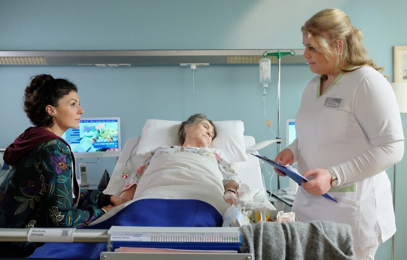 Rike Machold (Liza Tzschirner, li.) weicht ihrer Großmutter Elfriede (Karin Oehme, mi.) nicht von der Seite. Schwester Miriam (Christina Petersen, re.) mahnt die sympathische, junge Frau, auch an sich zu denken. Wann hat sie das letzte Mal etwas gegessen? – Bild: MDR /​ Sebastian Kiss