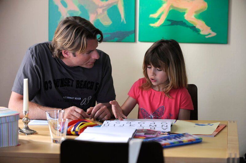 Überrascht stellt Sebastian fest, dass seine Tochter bereits schreiben kann. Von links: Sebastian Wildner (Herbert Ulrich) und Valentina Götz (Lilli Reulein). – Bild: Marco Orlando Pichler /​ BR