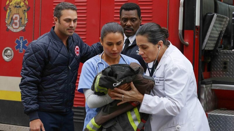 Chief Bodens (Eamonn Walker, r.) Frau, bekommt das gemeinsame Baby auf dem Weg zum Krankenhaus im Rüstwagen. Kelly Severide (Taylor Kinney), Krankenschwester (Olga Aguilar) und Ärztin (Amy J. Carle, r.) assistieren. – Bild: TVNOW /​ NBC Universal