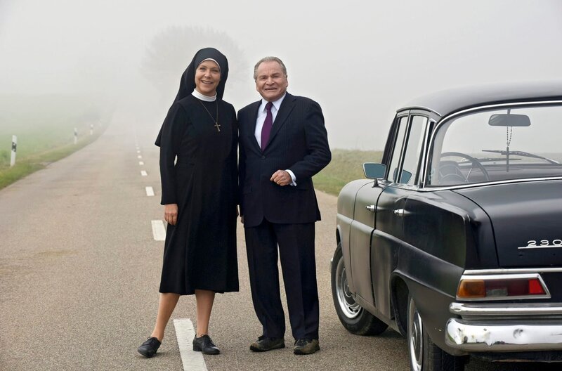 Schwester Hanna (Janina Hartwig, l.) hat Bürgermeister Wöller (Fritz Wepper, r.) aufgegabelt und nimmt ihn mit ins Kloster. – Bild: MDR/​ARD/​Barbara Bauriedl