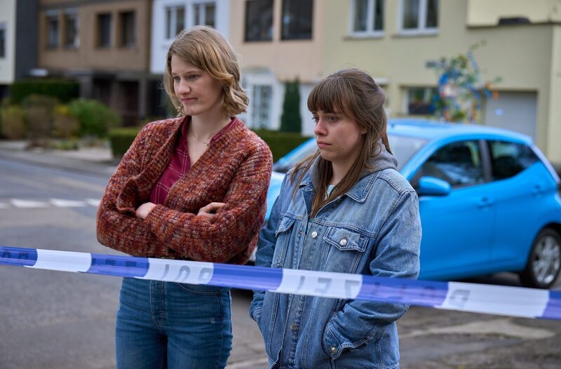 Vivien und Jenny stehen hinter der Polizeiabstimmung und schauen bedrückt auf den Fundort der Leiche. – Bild: ARD/​Frank Dicks