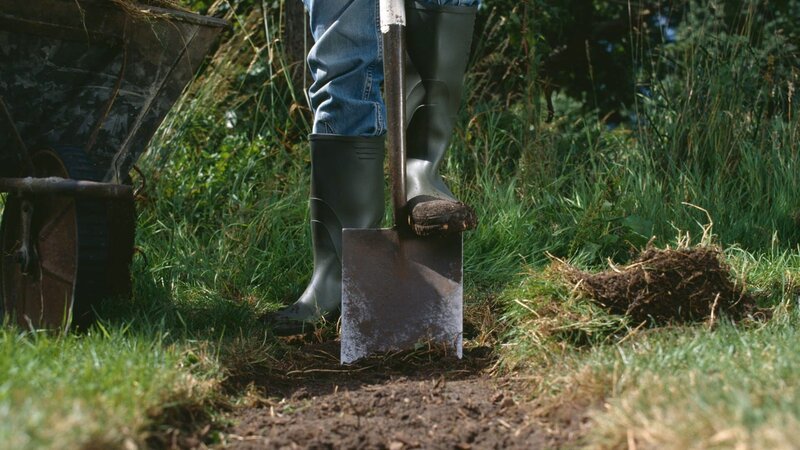 Young woman digging earth with shovel, low section – Bild: Dougal Waters