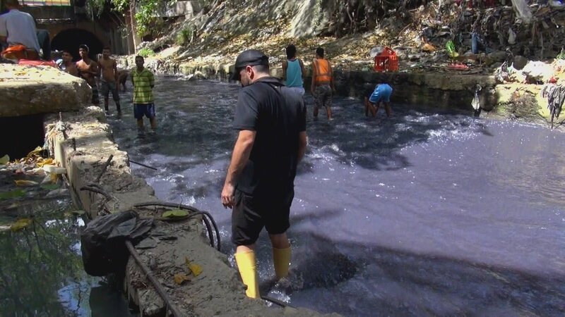 Männer suchen in einem mit Abwasser verunreinigten Fluss nach allem, was sich zu Geld machen lässt. – Bild: ZDF/​Capa /​ 13ičme Rue.