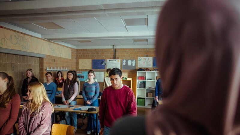 Ahmad verlässt den Klassenraum während der Schweigeminute zum 11.09.2001, weil er sich nicht beteiligen möchte. – Bild: Luis Engels