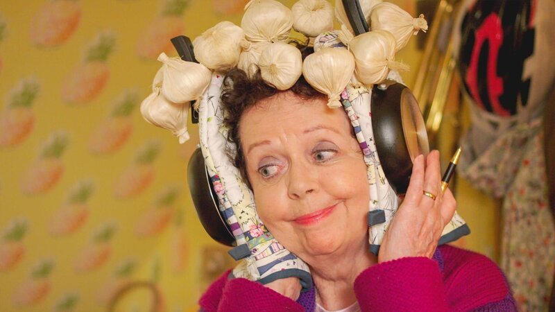 Frau Hobbs hält sich die Ohren zu, um Wuffels Gejammer nicht zu hören. – Bild: ZDF/​Darrall MacQueen