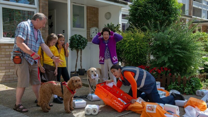 Entsetzt schauen Opa Dennis, Evi, Romy und Frau Hobbs sowie die Hunde Wuffel und Nelly zu, wie die Lieferantin der Klorollen stolpert. – Bild: ZDF/​Darrall MacQueen