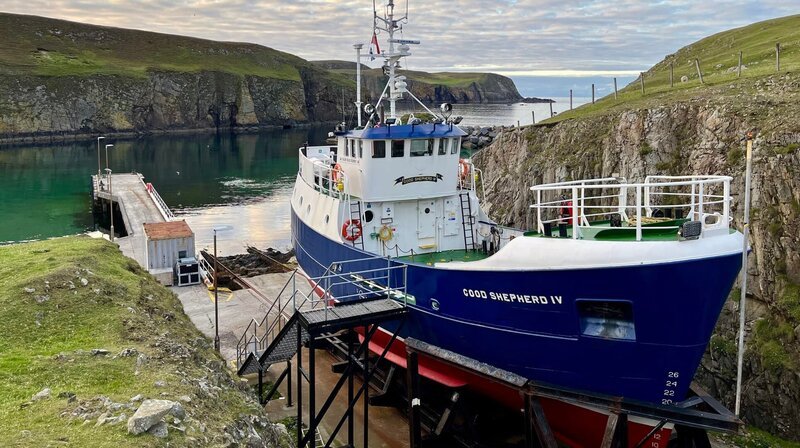 Die „Good Shepherd“ ist die Lebensader der kleinen Insel Fair Isle. Zum Schutz vor Wind und Wetter wartet sie zwischen den Felsen auf ihren nächsten Einsatz. – Bild: NDR/​Till Lehmann/​nonfictionplanet
