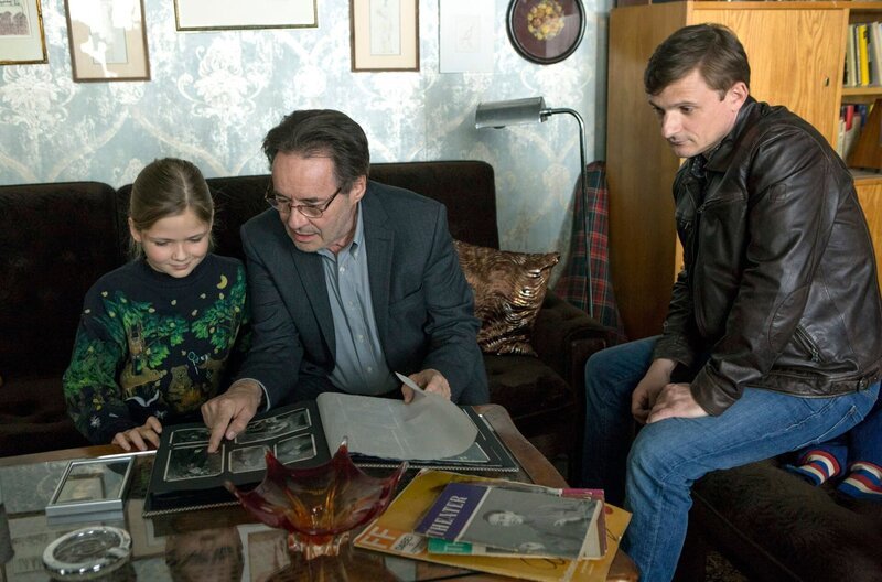 Anna (Ziva-Maria Faske, l.) interessiert sich für ihre Oma Dunja Hausmann. Hans (Uwe Kockisch, M.) zeigt seiner Enkelin Familienfotos, Martin (Florian Lukas, r.) schaut zu. – Bild: Julia von Vietinghoff