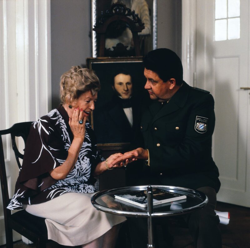 Frau Malik (Maria Paudler) und Moosgruber (Max Grießer). – Bild: BR/​Neue Münchner Fernsehproduktion