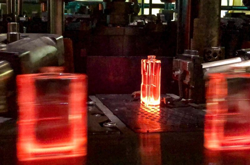 Auf der Glasmaschine entstehen aus flüssigem Glas die Flakons – bis zu 500 Stück pro Minute. Bei Temperaturen um 1000°C werden sie mittels Pressluft in Stahlformen ausgeblasen. – Bild: MDR/​Sascha Mönch