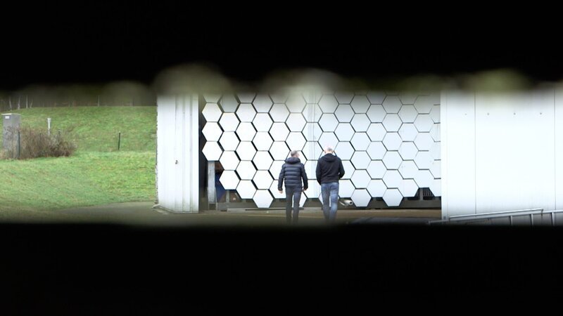 Der Sonnenofen sammelt Energie mit Spiegeln. Dr. Gerd Dibowski (rechts), Leiter der solaren Großanlagen am Deutschen Zentrum für Luft- und Raumfahrt in Köln, erhitzt damit Experimentierfelder auf über 2.500 Grad Celsius und kann Stahl zum Schmelzen bringen. Sonnenenergie für innovative Anwendungen in der Wissenschaft und in der Industrie. Ganz ohne Verbrennung fossiler Energieträger. Links: Moderator Karsten Schwanke. – Bild: BR/​Maximilian Schecker