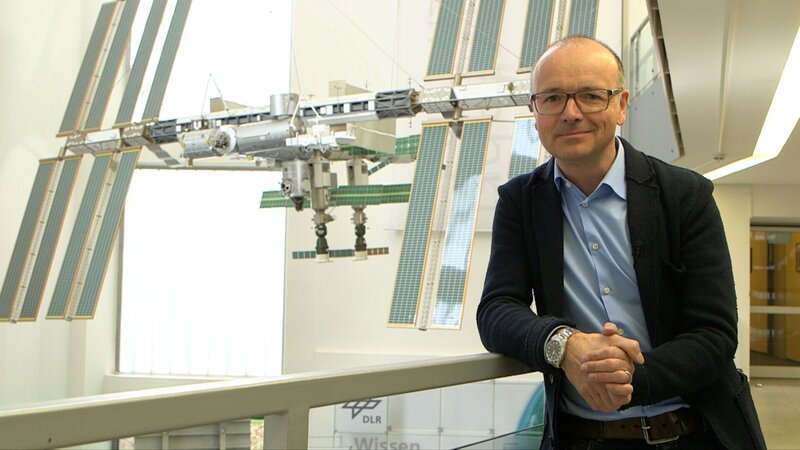 Karsten Schwanke vor einem Modell der Raumstation ISS beim Deutschen Zentrum für Luft- und Raumfahrt in Köln. – Bild: Maximilian Schecker