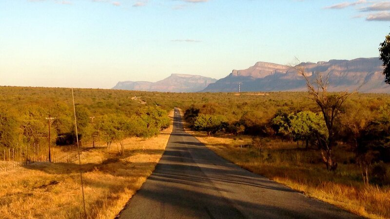 A road in the center of the desert leading to the mountains. – Bild: Discovery Communications