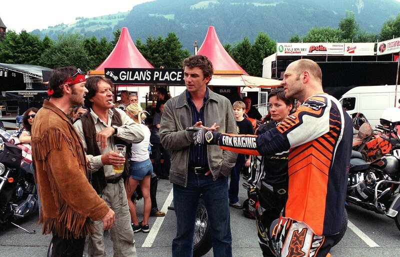 „Soko Kitzbühel“, „Die Wilden.“ Beim alljährlichen Treffen von Harley-Davidson-Fahrern in Kitzbühel kommt es zu einer Konfrontation zwischen ihnen und einer Gruppe von aggressiven Motocross-Fahrern. Wenig später wird einer der Motocrosser, Auer, auf der Rennstrecke bei Kundl ermordet aufgefunden. Keine leichte Aufgabe für Karin und Andreas zu klären, wem Auer im Weg gestanden sein könnte. Viele Verdächtige bieten sich an: Thomas Buchinger, ein Sägewerks- und Waldbesitzer und Eigner des Motocross-Geländes, David Gilan, der Chef eines Motorradshops in Wörgl, Franz Welt, ein Kollege und Freund des Toten, Sabine, die Ex-Freundin von Gilan, die sich kürzlich Alfred Auer zugewandt hatte. Diesmal ist es eine Idee von Andreas, die zur Rekonstruktion des Tathergangs und zur Überführung des Täters führt. Im Bild (v.li.): Michael Roll (David Gilan), Helmut Berger (Thomas Buchinger), Hans Sigl (Andreas Blitz), Jule Ronstedt (Sabine Ernst), Wolfram Rupperti (Alfred Auer). – Bild: ORF/​BEO-Film/​Laurent Trümper
