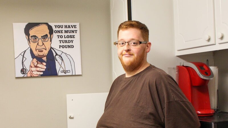 Justin poses with Dr Now wall art. – Bild: TLC /​ Discovery Communications, LLC
