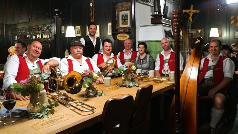 Servus Musikantenstammtisch Moderatoren Richard Deutinger und Conny Bürgler posieren für ein Foto mit dem Ebbser Kaiserklang. – Bild: Lena Moik /​ ServusTV /​ Degn Film
