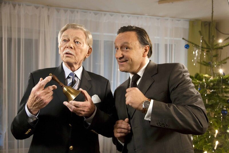 Bernhards (Frank Voß, rechts) Schwiegervater (Uwe Friedrichsen) findet die Bescherungsglocke einfach nur albern. – Bild: NDR/​Carsten Schick