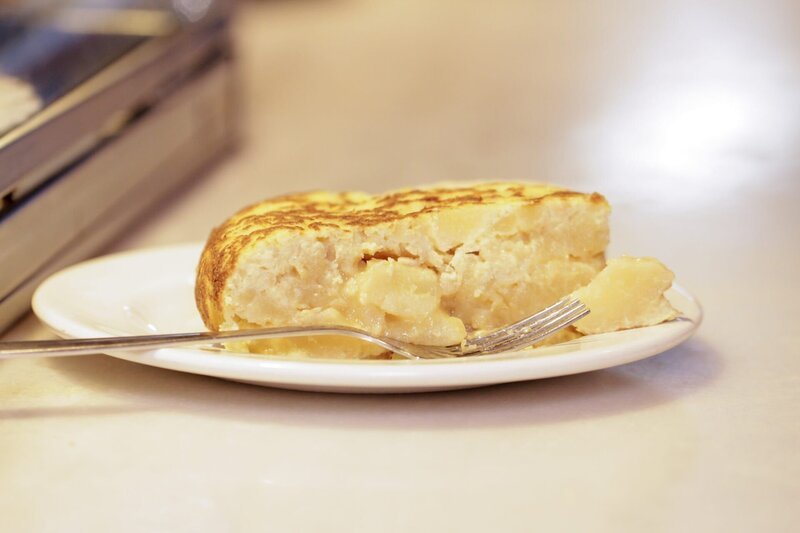 „Pincho de Tortilla“ ist ein gebratenes Omelett aus Kartoffeln und Ei, das in Scheiben geschnitten und als beliebte Tapa in Madrid serviert wird. – Bild: ORF/​Warner/​The Travel Channel