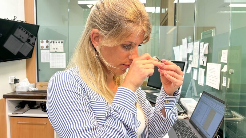 Franzi inspecting jewelry. – Bild: Warner Bros. Discovery, Inc. or its subsidiaries and affiliates.