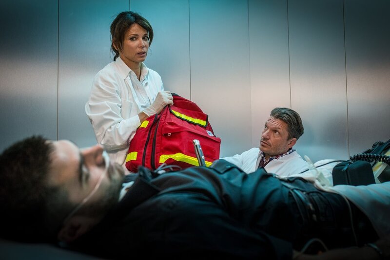 Dr. Jonas (Gerit Kling, M.) und Dr. Lindberg (Hardy Krüger Jr., r.) machen sich Sorgen. Die Stichverletzung ihres Patienten, des Drogendealers Tomas (Filip Grujic, l.), muss dringend im OP versorgt werden. – Bild: Boris Laewen