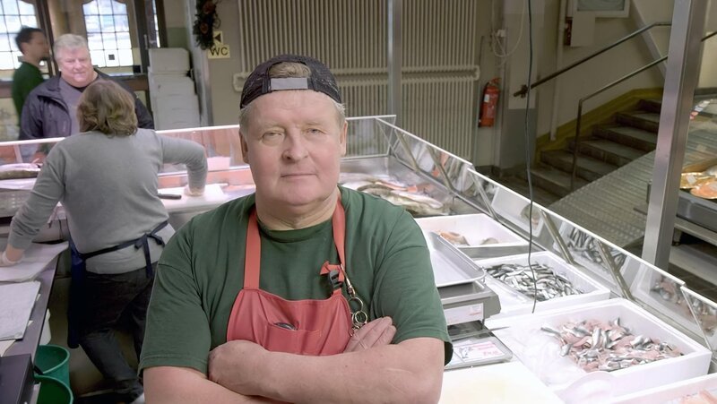 Fischhändler Kalevi Miettinen gibt den Kunden an seinem Stand in der Hakaniemen Markthalle in Helsinki gerne persönliche Kochtipps – Bild: ART