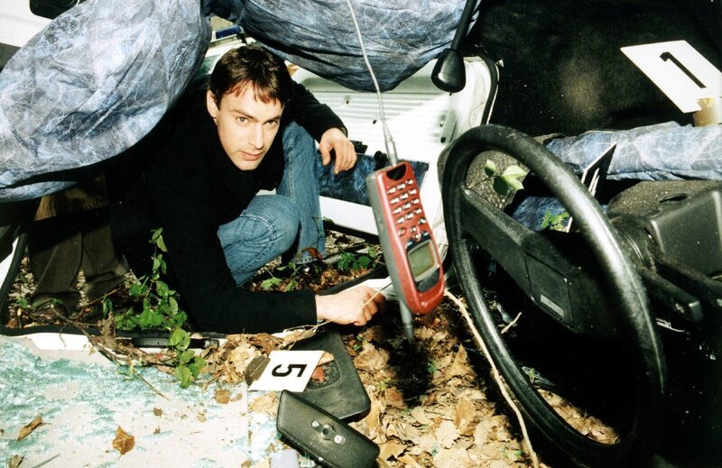 Kommissar Brandtner (Gedeon Burkhard) nimmt das Autowrack etwas genauer unter die Lupe. Er entdeckt ein Mobiltelefon. Hat die Verunglückte kurz vor ihrem Unfall ein Gespräch geführt? – Bild: SAT.1