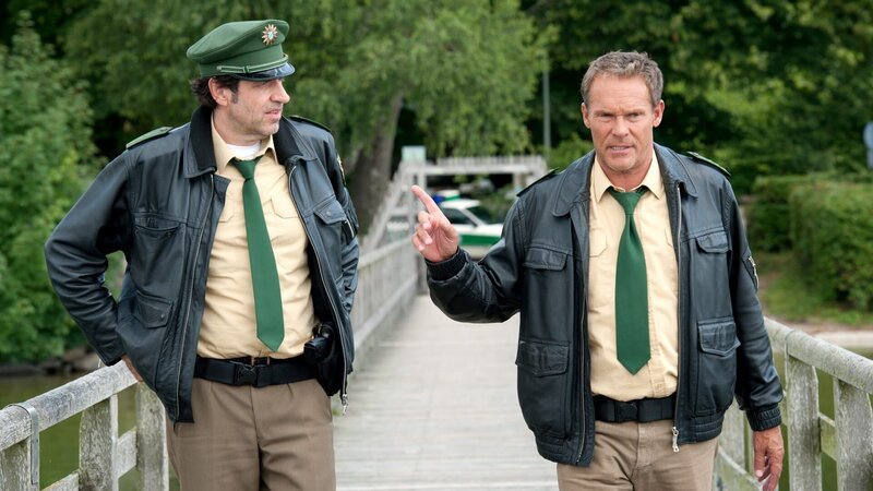L-R: Polizeiobermeister Johannes Staller (Helmfried von Lüttichau) and Polizeiobermeister Franz Hubert (Christian Tramitz) – Bild: Die Verwendung ist nur bei redak /​ Tele München /​ © TMG und Entertainment Factory