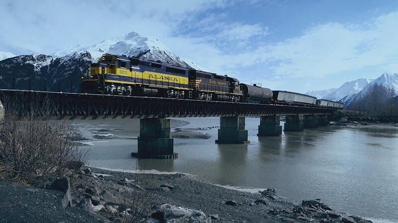Zugfahrt über die Brücke. – Bild: Warner Bros. Discovery