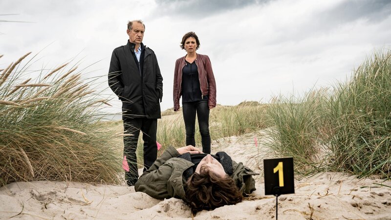 Leichenfund in den Dünen auf Sylt. Der Tote heißt Harald Piontek, anerkannter Kunstexperte und freier Kurator von Kunstausstellungen. Carl Sievers (Peter Heinrich Brix) und Ina Behrendsen (Julia Brendler) nehmen die Ermittlungen auf. – Bild: Georges Pauly /​ ZDF Enterprises GmbH /​ Die Verwendung ist nur bei redaktioneller Berichterstattung im Rahmen einer Programmankündigung ab 2 Monate vor der ersten Auss /​ © ZDF