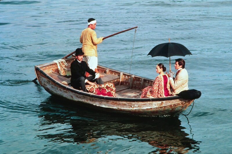 Jean Passepartout (Eric Idle, l.), Prinzessin Aouda (Julia Nickson) und Phileas Fogg (Pierce Brosnan, r.) – Bild: 1989 HARMONY GOLD PRODUCTIONS, INC.