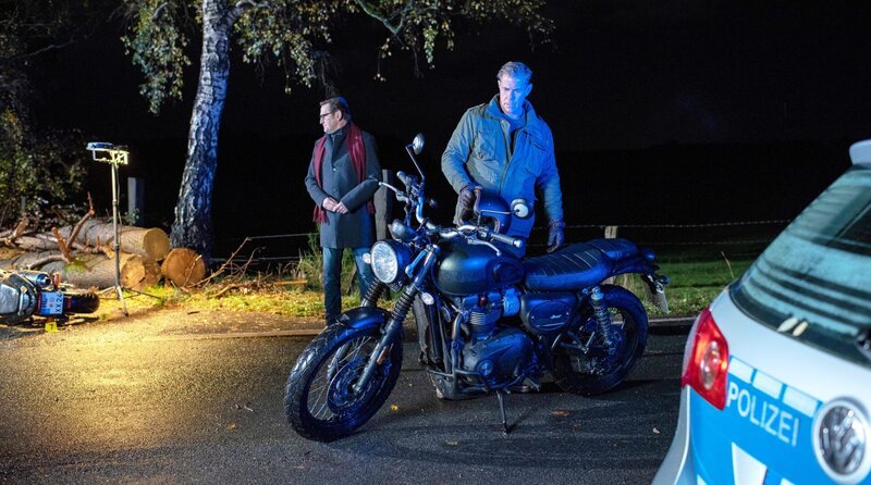 Der Inhaber eines neuen, großen Angelladens verunglückt tödlich mit seinem Motorrad. Finn (Sven Martinek, r.) und Lars (Ingo Naujoks, l.) wird schnell klar, dass jemand mit Streusplit den Unfall herbeigeführt hat. – Bild: OneGate /​ Die Verwendung ist nur bei redaktioneller Berichterstattung im Rahmen einer Programmankündigung ab 2 Monate vor der ersten Auss /​ © Degeto Film GmbH