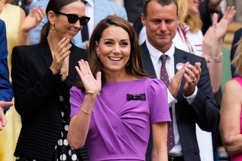 Kate, Prinzessin von Wales, winkt, als sie vor dem Finale der Herren-Einzel bei den Wimbledon-Tennismeisterschaften in London auf dem Centre Court ankommt. – Bild: AP Photo /​ Kirsty Wigglesworth