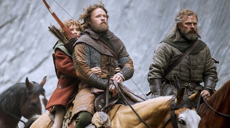 Der Räuberhauptmann Mattis (Christopher Wagelin, Mitte) mit seiner Tochter Ronja (Kerstin Linden, li.). – Bild: 2023 Viaplay Group/​Filmlance International AB/​Film i Väst/​Ahil Films/​ARD Degeto Film/​Audrius Solominas