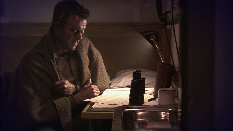 Ein Mann sitzt an einem Schreibtisch und liest ein Dokument – Bild: 2020 HOFF PRODUCTIONS /​ THE HISTORY CHANNEL