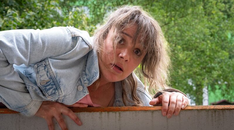 Panisch ergreift Agnetha Pfeiffer (Alwara Höfels) vor dem Gerichtsvollzieher die Flucht über ihren Balkon. – Bild: NDR/​Boris Laewen