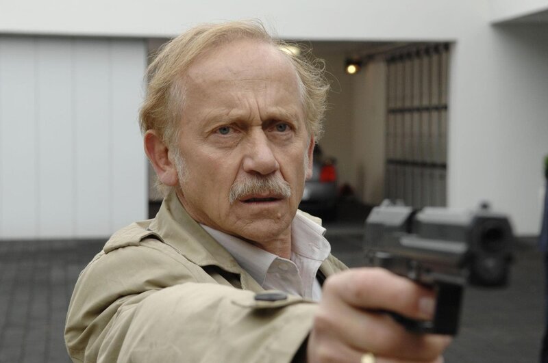 Als Kowalski (Tilo Prückner) mit Dr. Hoch zu dessen Haus kommt, um Beweise zu sichern, versucht dieser zu fliehen. Der Versuch scheitert und Kowalski richtet eine Waffe auf ihn … – Bild: RTL /​ Guido Engels