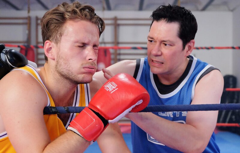 Kevin Müller (Nicolas Wolf, links) hat Philipp Brentano (Thomas Koch) einen kleinen Sparringskampf angeboten. Da er Philipp jedoch leicht unterschätzt und sich nicht richtig deckt, erwischt Philipp ihn direkt am Auge auf das schon vorhandene Veilchen. Kevin muss direkt in die Klinik. – Bild: BR/​MDR/​Saxonia Media/​Sebastian Kiss
