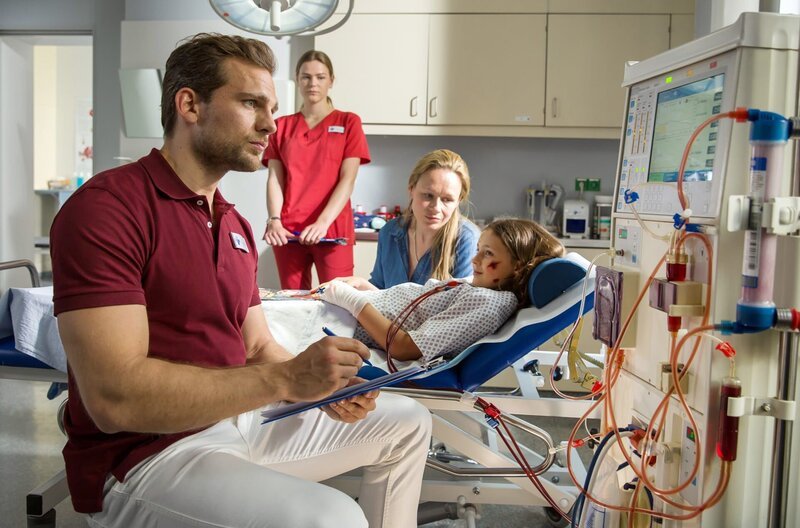 Sophie Witte (Anja Schneider, 2.v.r.) macht sich große Sorgen um ihre Adoptivtochter Kiki (Anais Sterneckert, r.). Darius (Moritz Otto, l.) stellt fest, dass nur noch eine Lebertransplantation das kleine Mädchen retten kann (mit Llewellyn Reichman, 2.v.l.). – Bild: ARD/​Daniela Incoronato