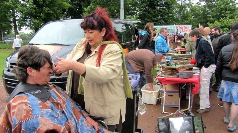 Sogar auf dem Flohmarkt werden von Sonja Haare geschnitten.. (Foto, hinten: Experte Otto Schulte)Sogar auf dem Flohmarkt werden von Sonja Haare geschnitten.. (Foto, hinten: Experte Otto Schulte) – Bild: RTL Zwei