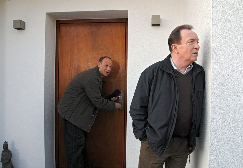 Kain (Bernd Michael Lade, links) und Ehrlicher (Peter Sodann, rechts) öffnen ohne richterlichen Beschluss das Haus von Hans Meier. Sie vermuten Gefahr in Verzug. – Bild: MDR/​Hardy Spitz