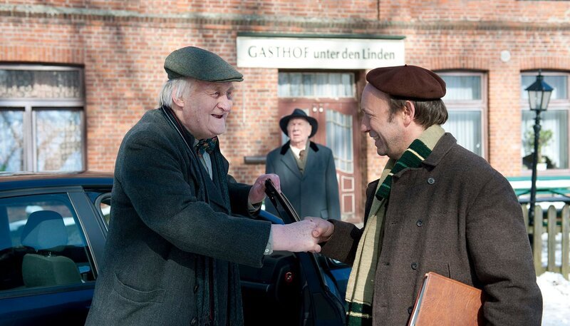 Onkel Krischan (Hans Kahlert, li.), Bürgermeister Schönbiehl (Günter Kütemeyer, Mitte) und Kuno (Sven walser, re.) auf dem Weg in den Dorfkrug. – Bild: NDR/​Nicolas Maack
