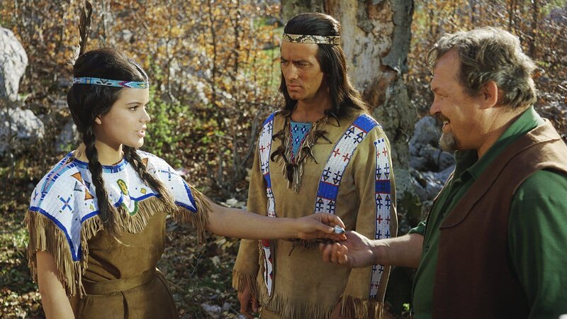 In Gegenwart von Winnetou (Pierre Brice, M.) hat Apanatschi (Uschi Glas, l.) von ihrem Vater Mac Haller (Walter Barnes, r.) ein besonderes Geburtstagsgeschenk erhalten. Doch ihre Freude hält sich in Grenzen. – Bild: ZDF und Gerd-Victor Krau In Gegenwart von Winnetou (Pierre Brice, M.) hat Apanatschi (Uschi Glas, l.) von ihrem Vater Mac Haller (Walter Barnes, r.) ein besonderes Geburtstagsgeschenk erhalten. Doch ihre Freude hält sich in Grenzen. – Bild: ZDF und Gerd-Victor Krau