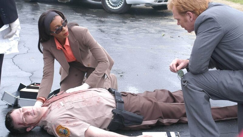 Während einer routinemäßigen Verkehrskontrolle wurde der Streifenpolizist Rich Insko (Brady Smith, lieg.) erschossen. Alexx Woods (Khandi Alexander) untersucht die Leiche und liefert Horatio (David Caruso, re.) erste Informationen. – Bild: SUPER RTL Während einer routinemäßigen Verkehrskontrolle wurde der Streifenpolizist Rich Insko (Brady Smith, lieg.) erschossen. Alexx Woods (Khandi Alexander) untersucht die Leiche und liefert Horatio (David Caruso, re.) erste Informationen. – Bild: SUPER RTL