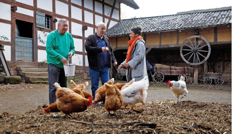 Jetzt wird’s bunt! Armin (Mitte), Clarissa (r) und Christophs Zeitreise führt durch die 80er Jahre. Es ist das Jahrzehnt, in dem Christoph zum ersten Mal auch vor der Maus-Kamera zu sehen ist. Im Freilichtmuseum Kommern erzählt er Clarissa, wie er als Regisseur vor der Kamera landete und was ein Nagelbrett und Tomatenketchup damit zu tun haben. Ganz besonders freut sich Clarissa auch darüber, Janoschs „Komm wir finden einen Schatz“ wiederzusehen. Das ist eine von vielen Lach- und Sachgeschichten aus den 1980ern, die Kinder von damals, heute mit ihrem eigenen Nachwuchs neu entdecken … – Bild: WDR/​Michael Schwettmann