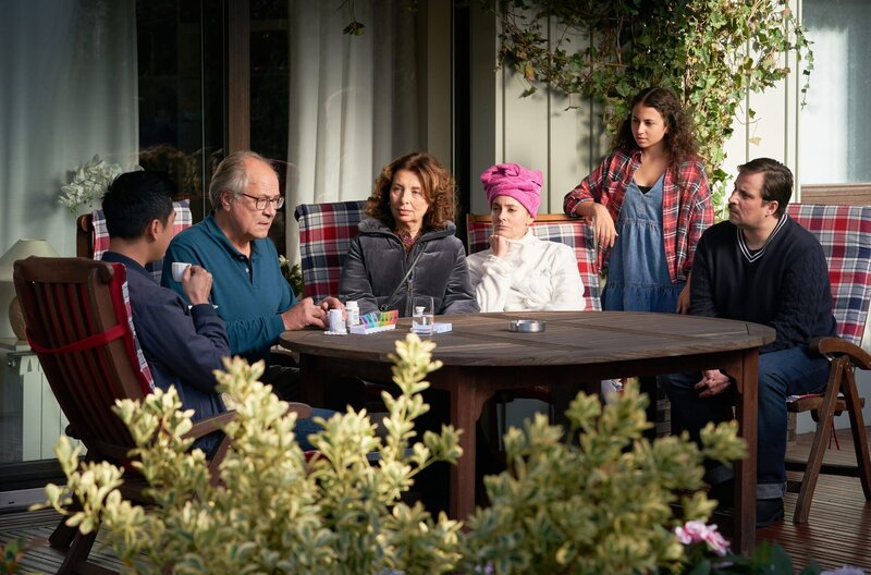 Klaus Schmitz (Hartmut Volle, 2.v.l.) sitzt mit Francesca (Teresa Harder, 4.v.r.), Daniela (Alice Gruia, 3.v.l.), Jens (Nikolai Will, l.) und Emiliana (Valentina Leone, 2.v.l.) auf der Terrasse. Hui Ko (Aaron Le, l.) bittet ihn um seine Mithilfe im Fall. – Bild: ARD/​Guido Engels