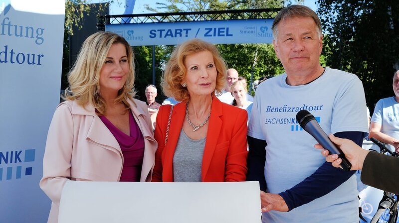 Sarah Marquardt, Ingrid Rischke und Dr. Roland Heilmann geben den interessierten Journalisten Auskunft über die Benefiz-Radtour zu Gunsten der Gernot-Simoni-Stiftung. – Bild: MDR/​Saxonia Media/​Sebastian Kiss